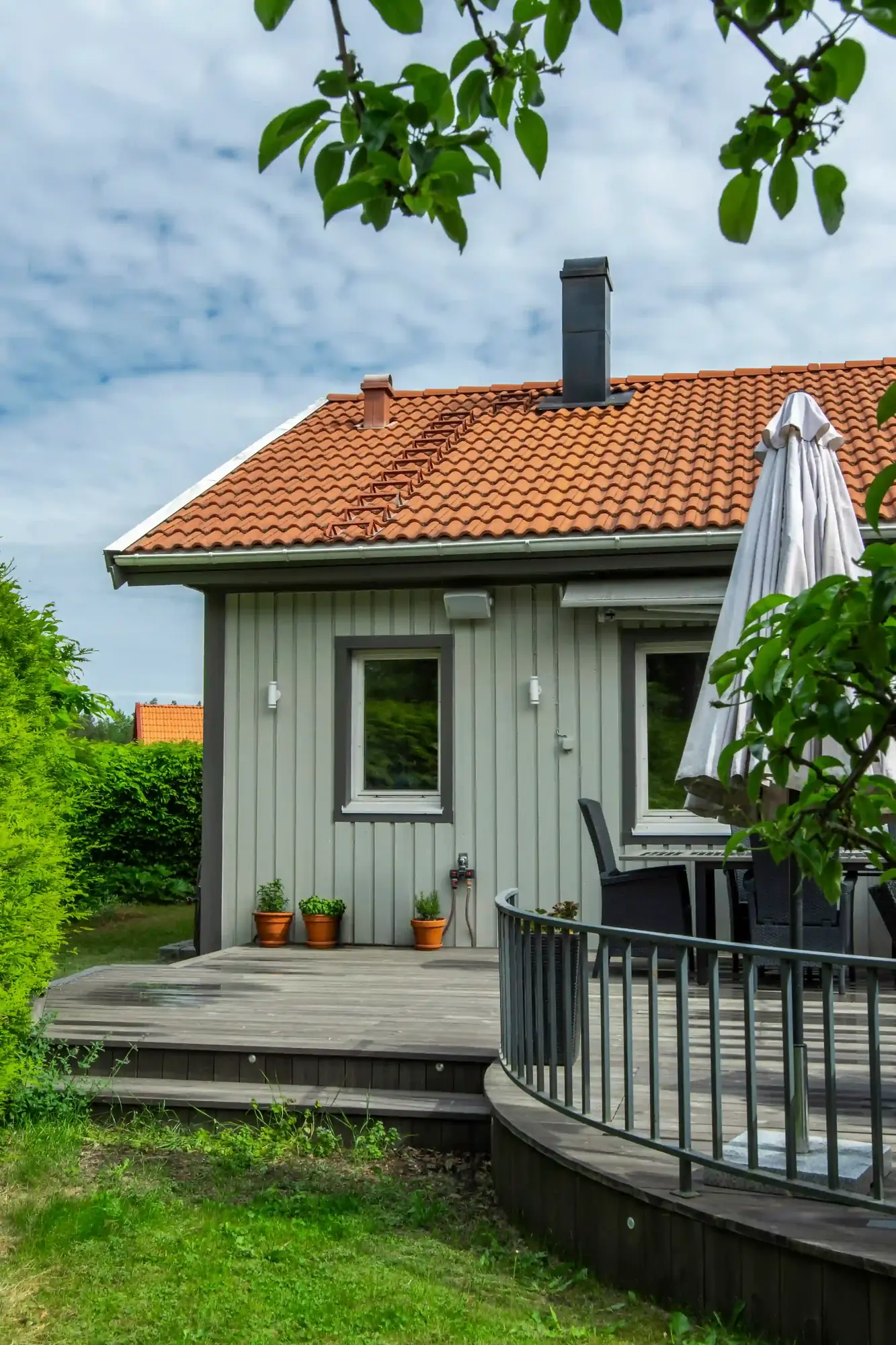Fasadmålning med varm beige och mörka foder